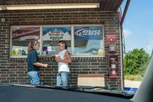Deux hommes discutent devant une station service